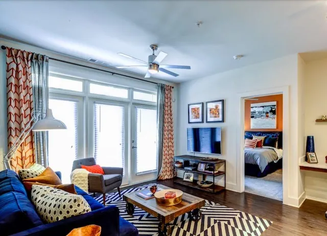 a living room with furniture a table and a large window