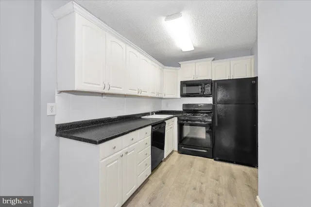 a kitchen with kitchen island granite countertop white cabinets and stainless steel appliances