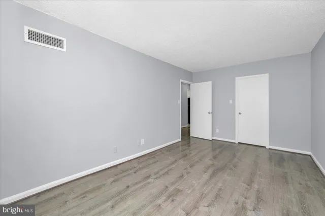 a view of an empty room with wooden floor