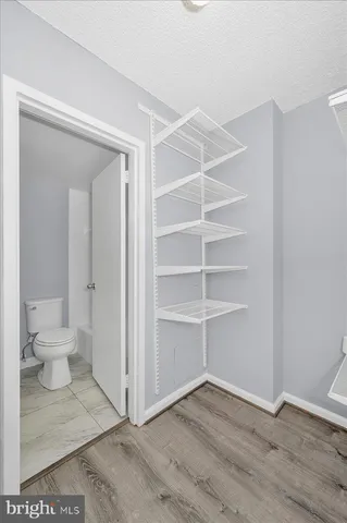 a view of a room with wooden floor and a toilet