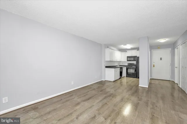 a view of kitchen with refrigerator and wooden floor