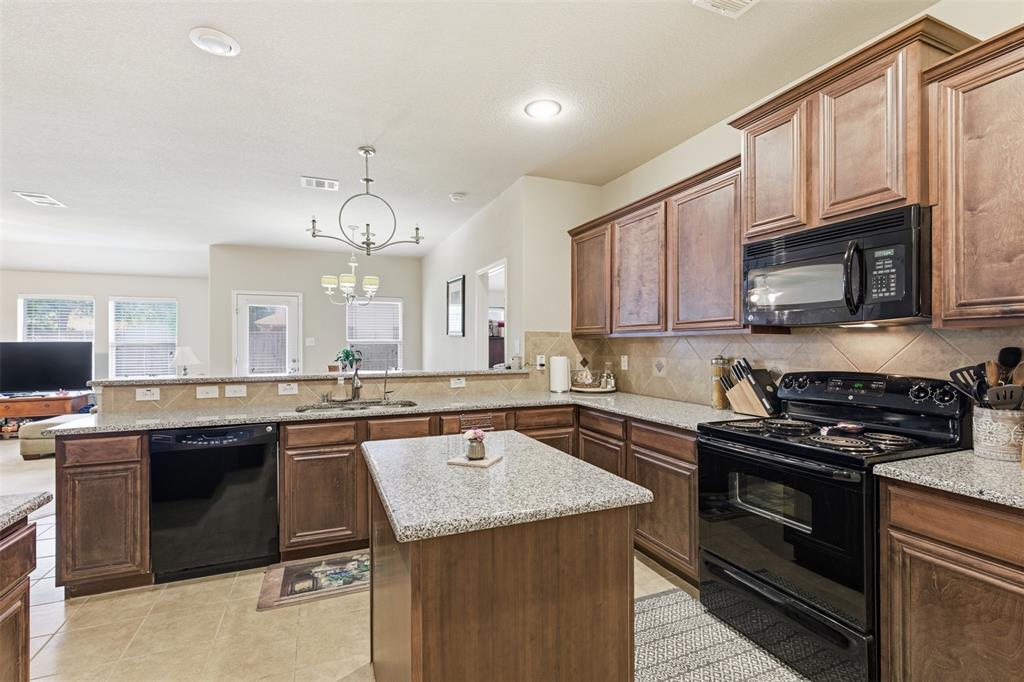 5491 Exeter Drive Prosper, TX 75078 - Photo 4 of 20 a kitchen with a sink stove top oven and cabinets