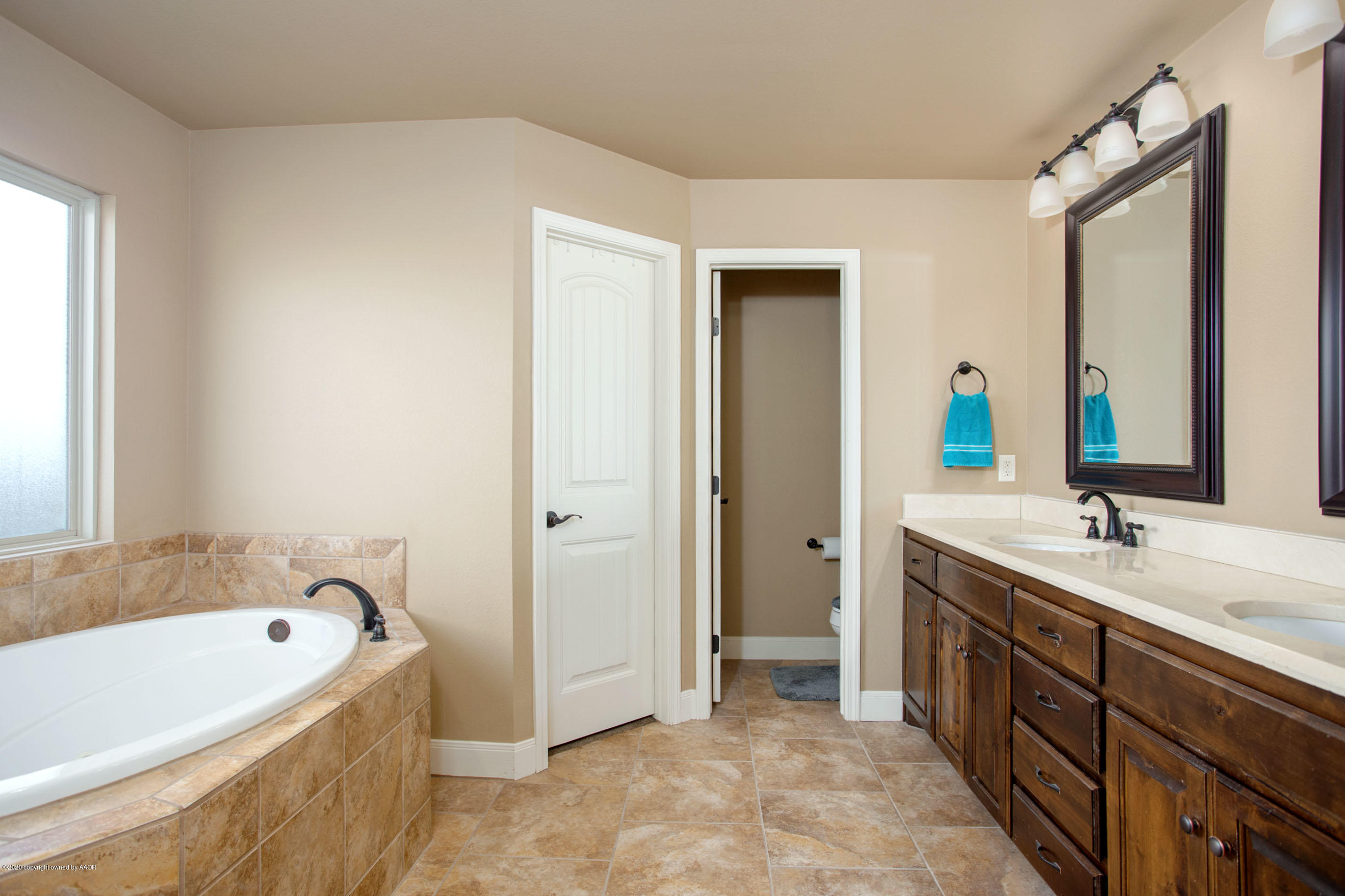3917 Arden Road Amarillo, TX 79118 - Photo 9 of 17 a spacious bathroom with a tub sink and mirror