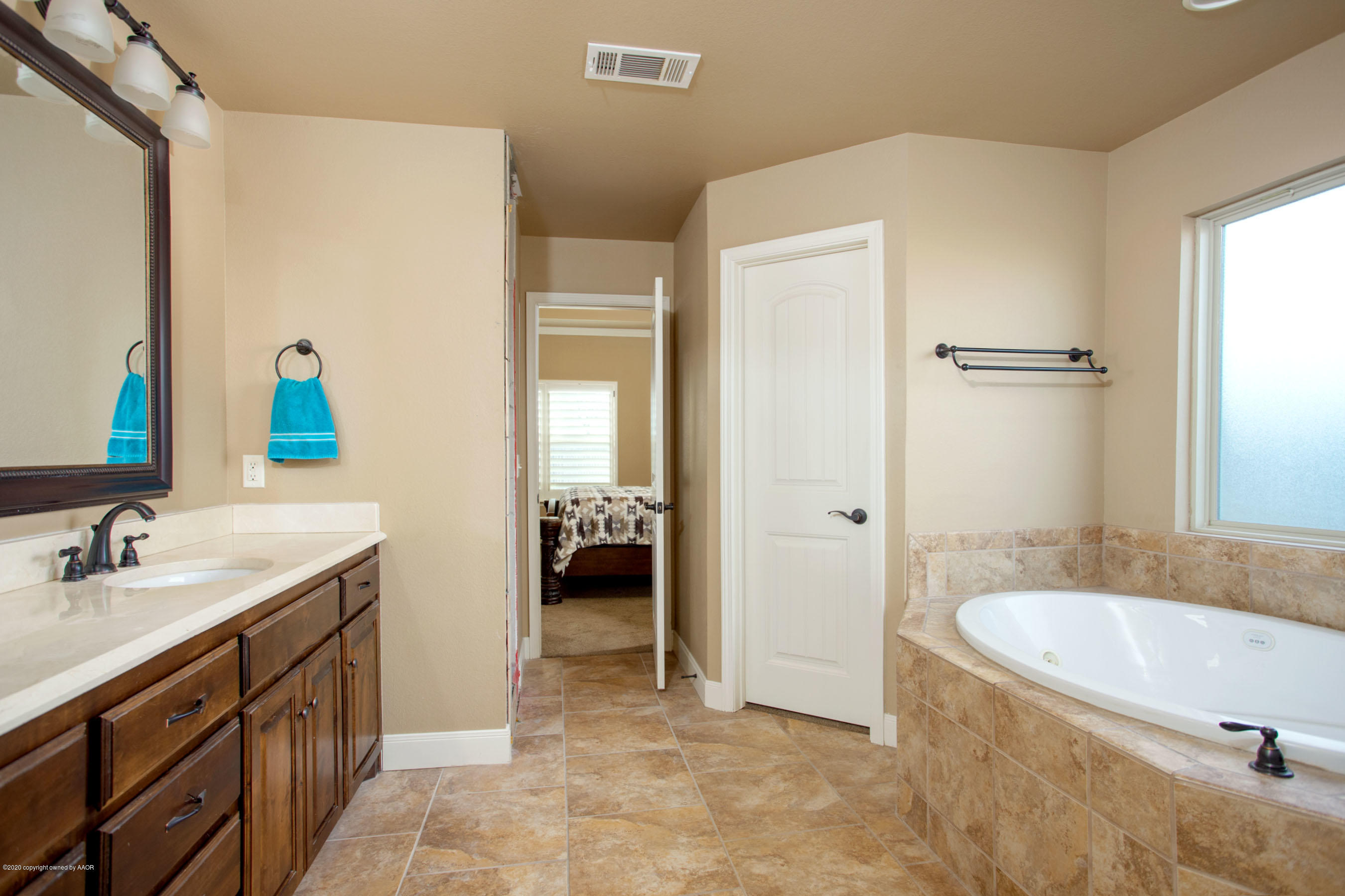 3917 Arden Road Amarillo, TX 79118 - Photo 10 of 17 a spacious bathroom with a granite countertop sink and a mirror