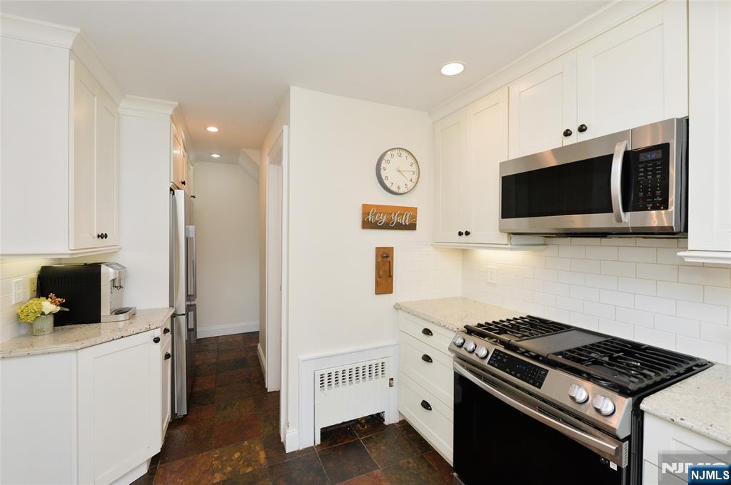 570 Shelton Road Ridgewood, NJ 07450 - Photo 10 of 26 a kitchen with stainless steel appliances a stove a microwave and cabinets