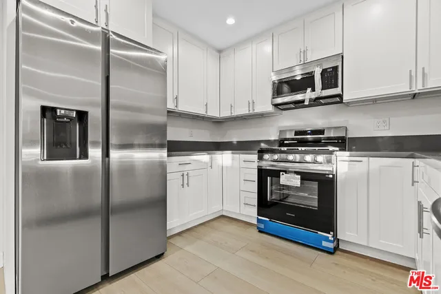a kitchen with stainless steel appliances granite countertop a stove a microwave and a refrigerator