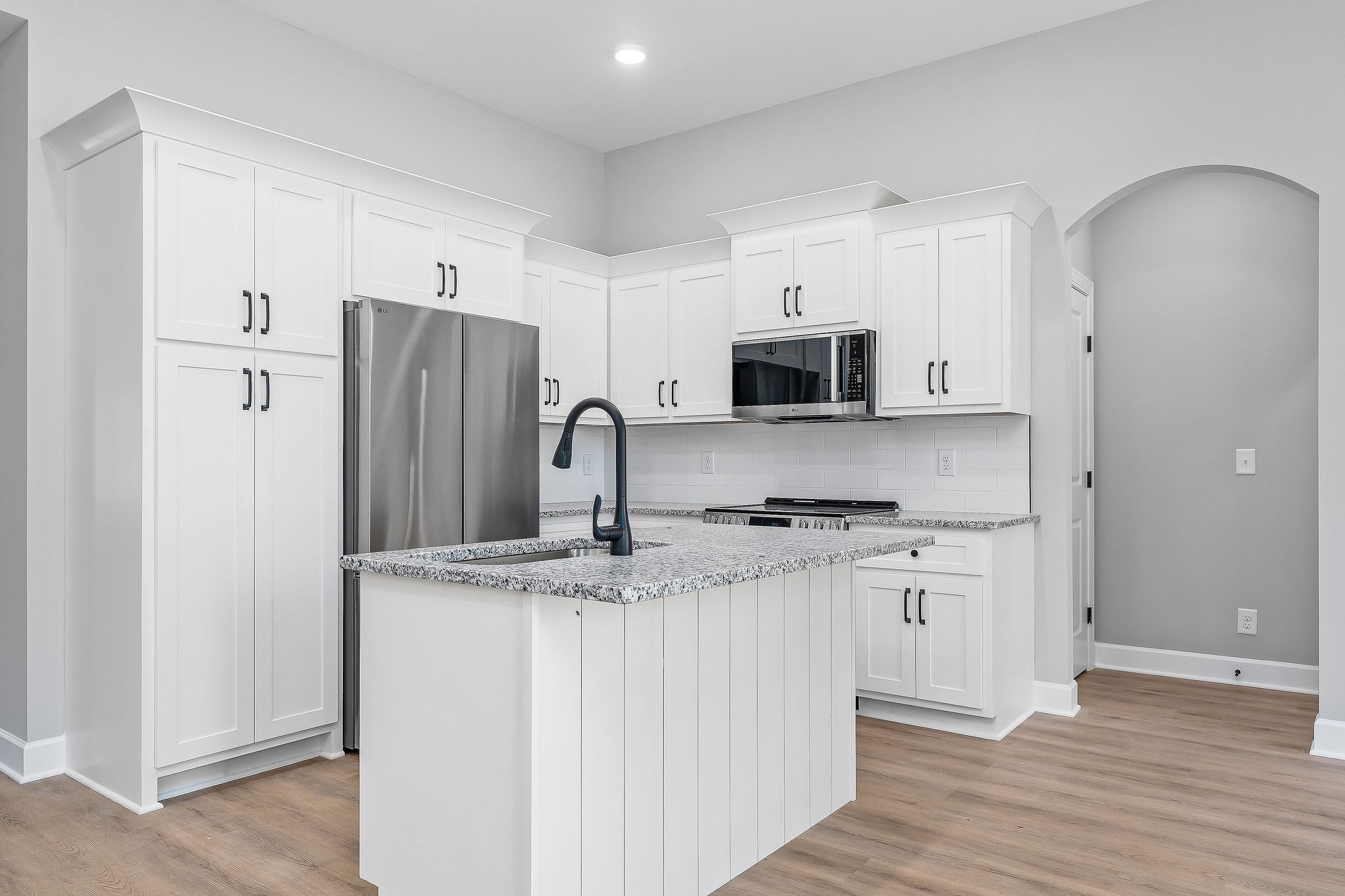 105 Reece Road Baxter, TN 38544 - Photo 14 of 33 a kitchen with stainless steel appliances granite countertop a refrigerator a stove a sink and white cabinets with wooden floor