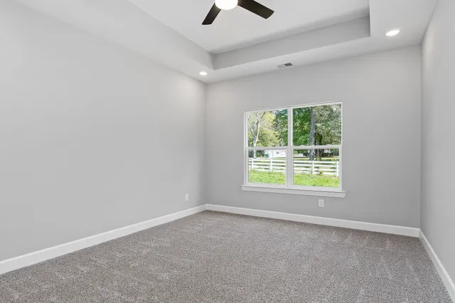 an empty room with a window and a ceiling fan