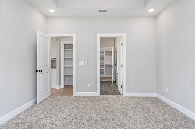 an empty room with closet and wooden floor