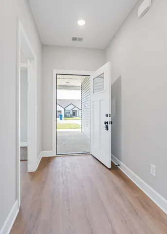 an empty room with wooden floor and door