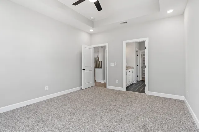 an empty room with ceiling fan and entryway
