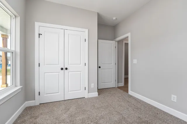 an empty room with windows and closet
