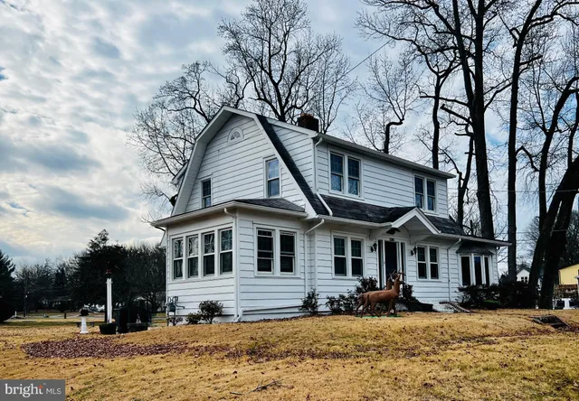 a front view of a house with a yard covered with snow