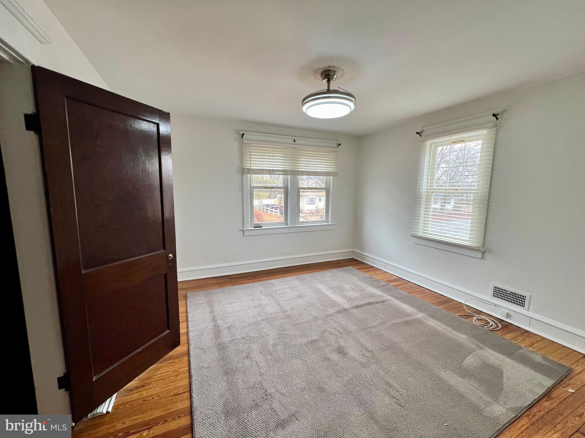 222 Berlin Road North Lindenwold, NJ 08021 - Photo 21 of 26 a view of an empty room with window and wooden floor