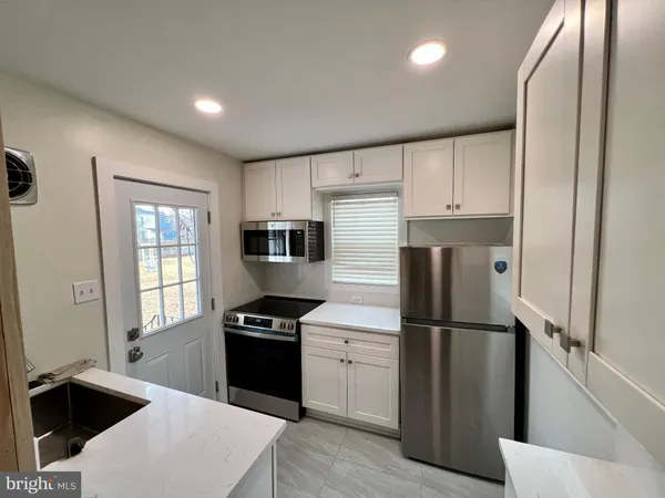 a kitchen with a refrigerator a sink and a stove top oven