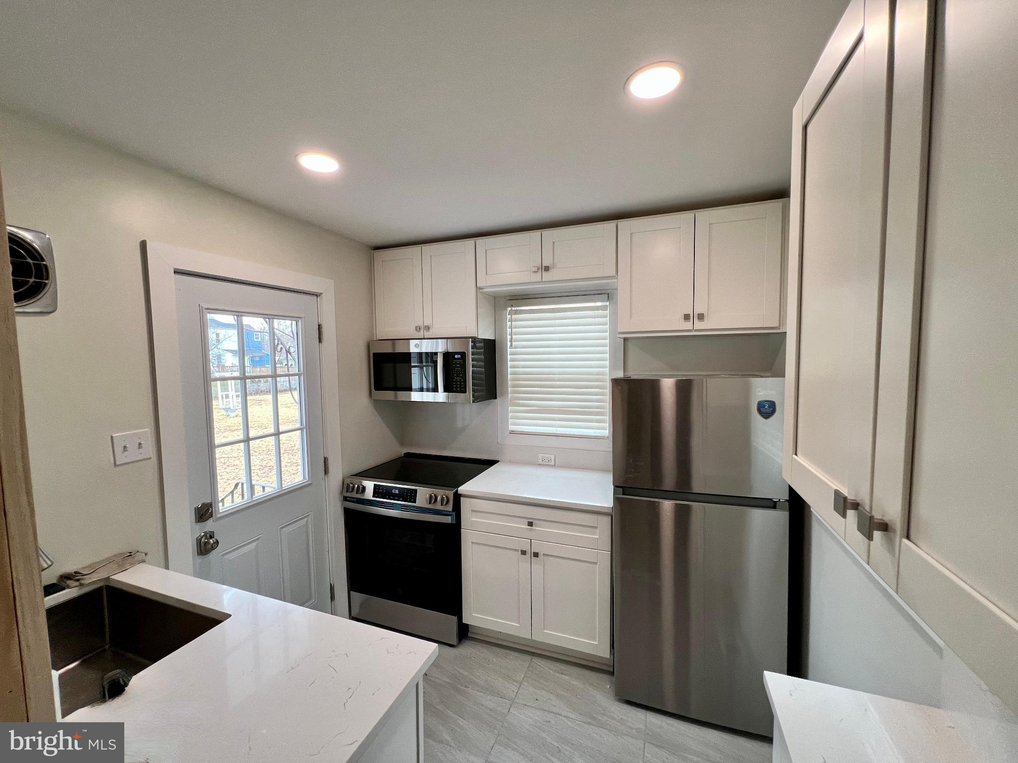 222 Berlin Road North Lindenwold, NJ 08021 - Photo 8 of 26 a kitchen with a refrigerator a sink and a stove top oven
