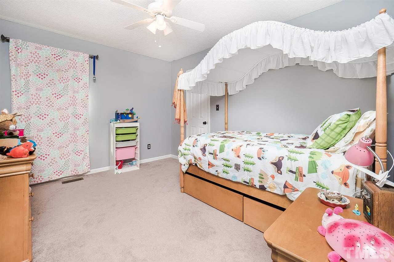 4125 Cobble Court Raleigh, NC 27616 - Photo 9 of 13 a bedroom with bed and a chandelier