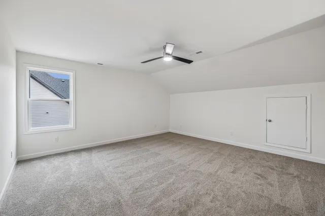 an empty room with a ceiling fan and window