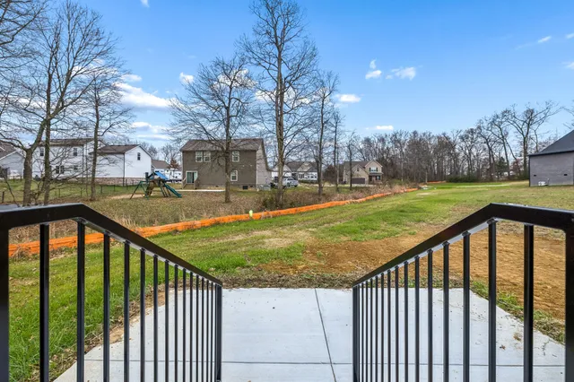 a view of a street with a yard and trees