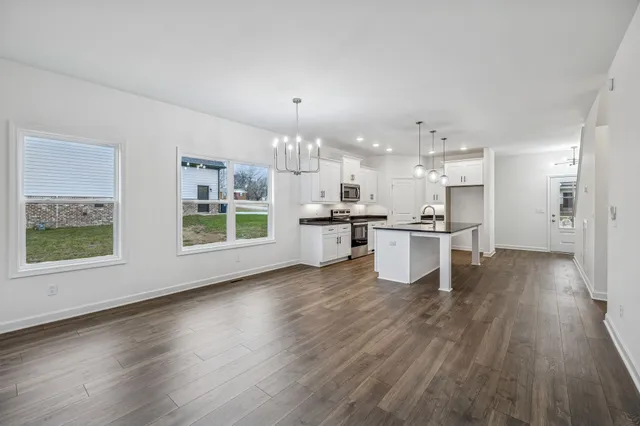 a kitchen with stainless steel appliances kitchen island wooden floors and view living room