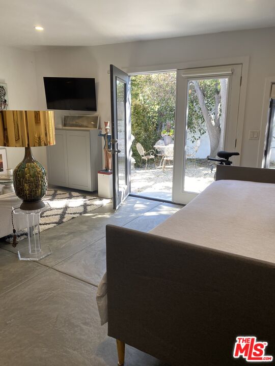 1053 South Alfred Street, Unit A Los Angeles, CA 90035 - Photo 4 of 11 a living room with a flat screen tv and a floor to ceiling window