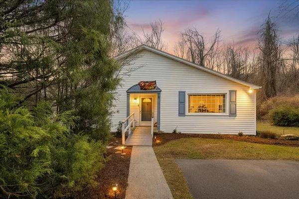 a view of a house with backyard and trees