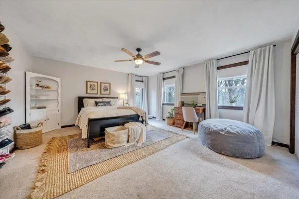 a spacious bedroom with a bed and a chandelier