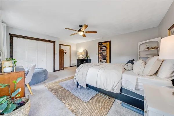 a spacious bedroom with a bed and ceiling fan