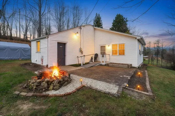 a backyard of a house with yard fire pit and outdoor seating