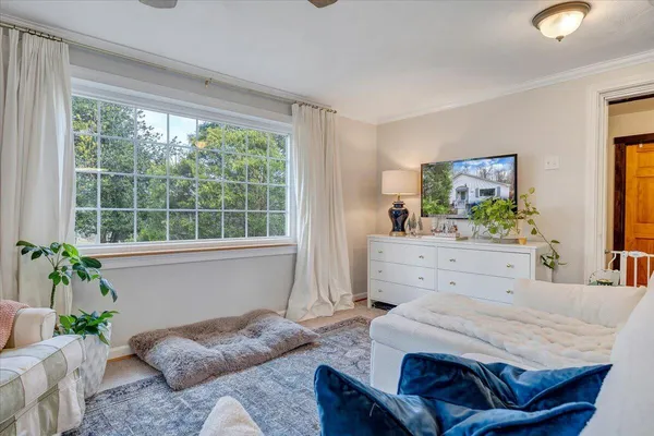 a bedroom with a bed and large windows