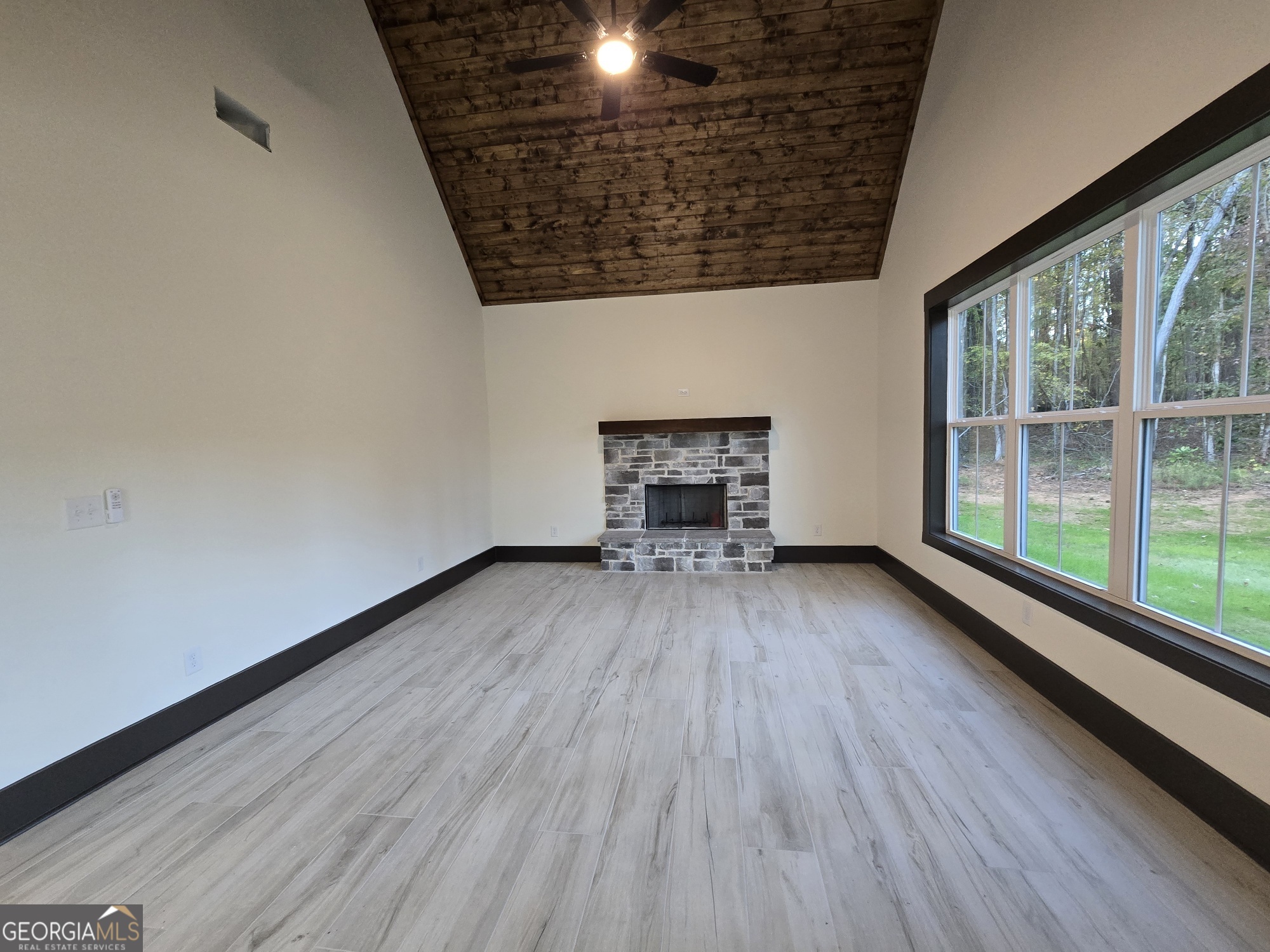2043 Fischer Road Sharpsburg, GA 30277 - Photo 22 of 51 a view of empty room with wooden floor and fireplace