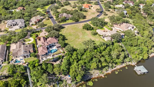 an aerial view of residential houses with outdoor space and trees