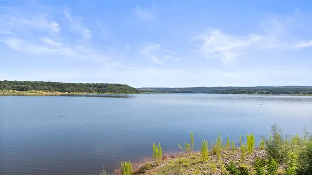 a view of a house with swimming pool and trees in the background