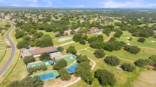 an aerial view of residential houses with outdoor space and trees