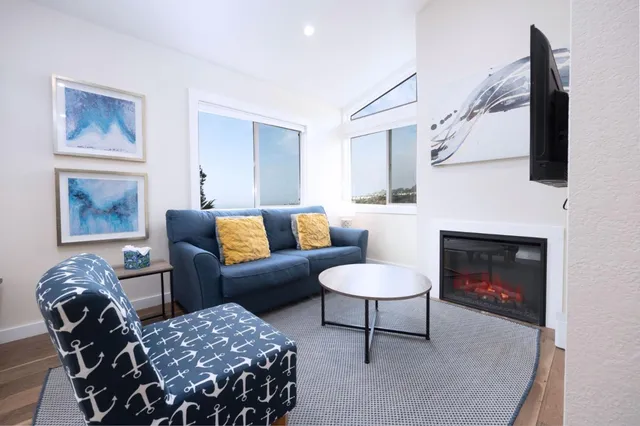 a living room with furniture a fireplace and a flat screen tv
