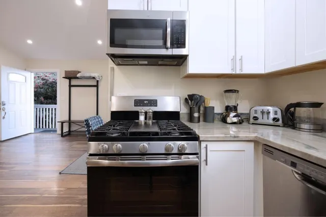 a kitchen with stainless steel appliances granite countertop a stove and a microwave