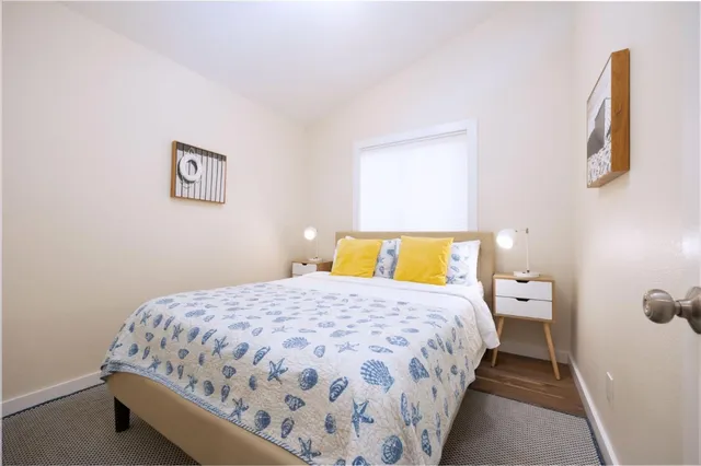 a bedroom with a bed and painting on the wall