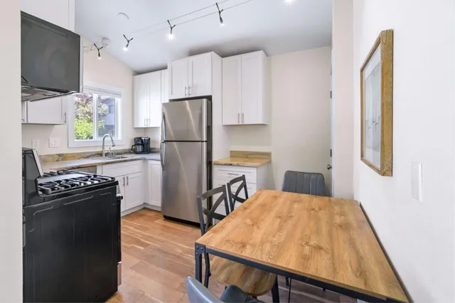 a kitchen with a refrigerator a stove a microwave oven a sink and dishwasher with wooden floor