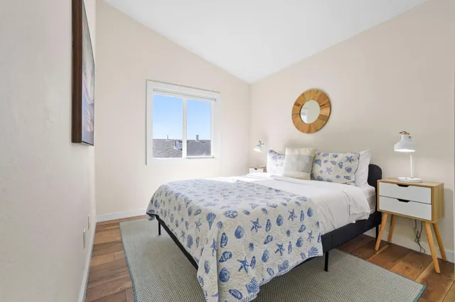 a bedroom with a bed and painting on the wall