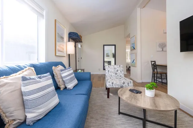 a living room with furniture a flat screen tv and a large window