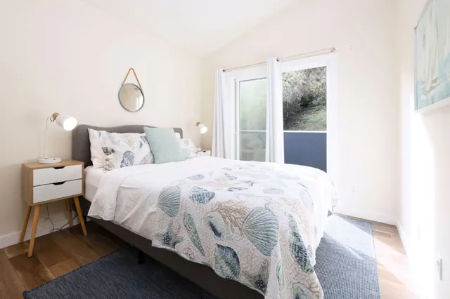 a large bed sitting in a bedroom next to a window