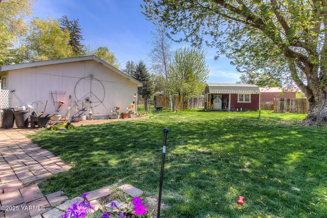 a backyard of a house with table and chairs