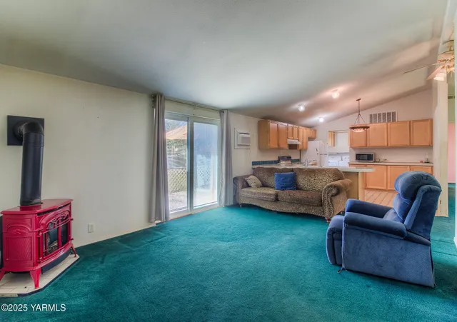 a living room with furniture and a open kitchen view