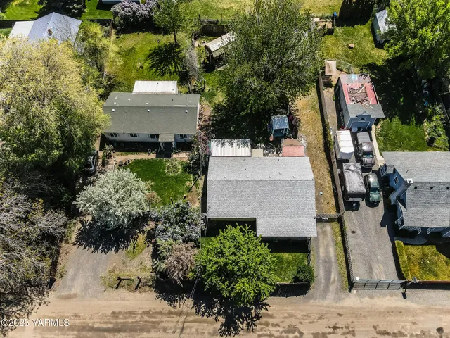 an aerial view of a house with a yard and large tree
