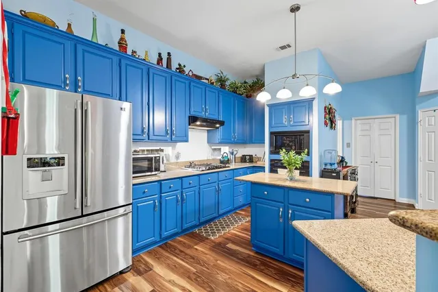 a kitchen with wooden floors and wooden cabinets