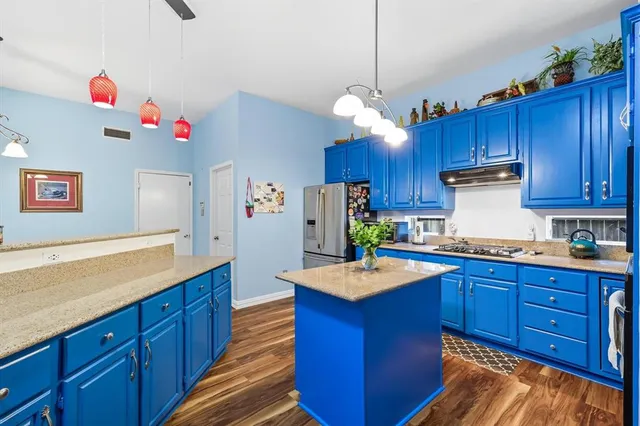 a kitchen with wooden cabinets and wooden floors