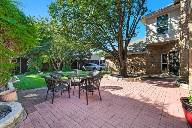 a backyard of a house with table and chairs
