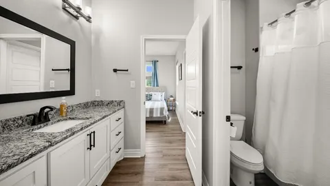 a en suite bathroom with a granite countertop sink toilet and a mirror