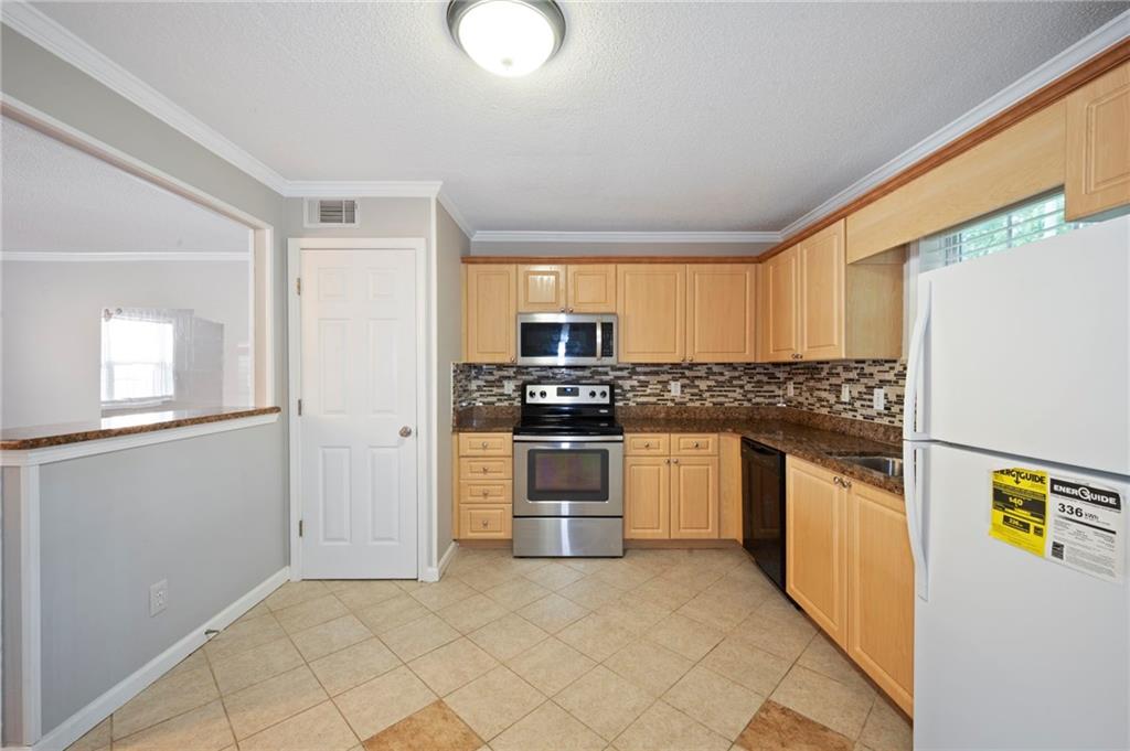 3665 Chestnut Drive, Unit D3 Atlanta, GA 30340 - Photo 13 of 16 a kitchen with stainless steel appliances granite countertop a stove a sink and a refrigerator