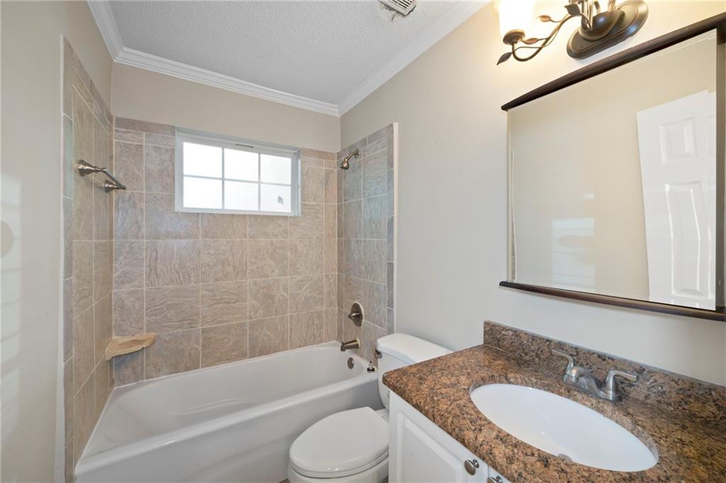 3665 Chestnut Drive, Unit D3 Atlanta, GA 30340 - Photo 7 of 16 a bathroom with a granite countertop sink toilet bathtub and shower